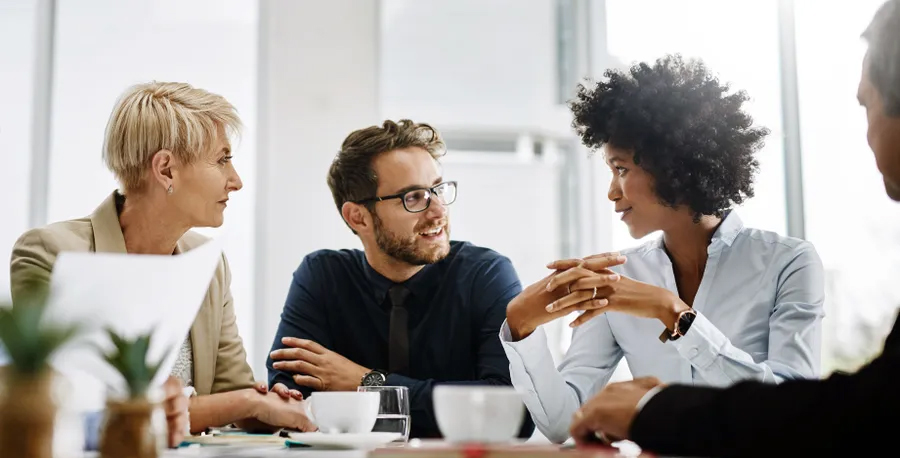 Image of people sitting at a desk talking